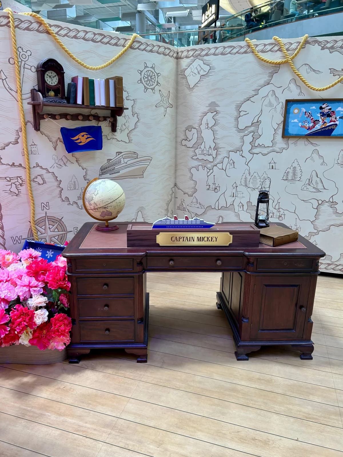 Disney Cruise Line Captain Mickey desk display with a globe and nautical map backdrop at Changi Airport