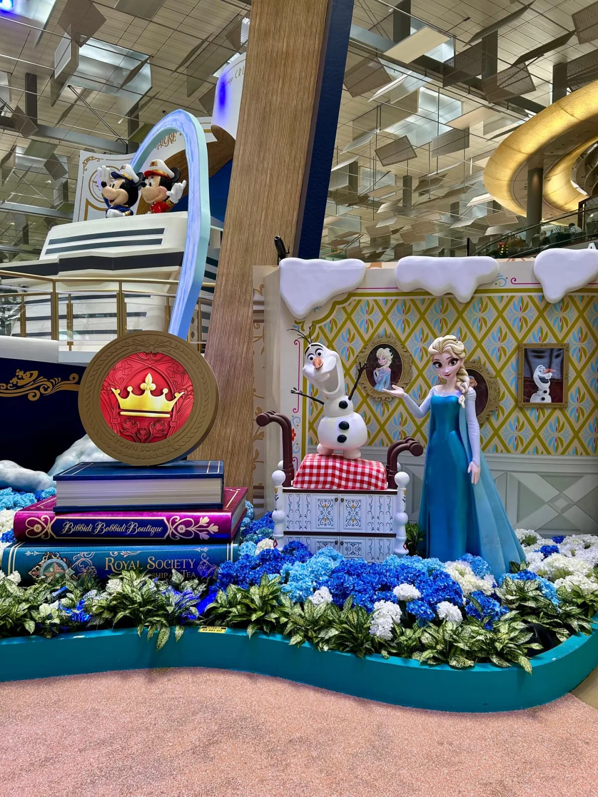 Frozen-themed Disney display with Elsa and Olaf beside oversized storybooks at Changi Airport
