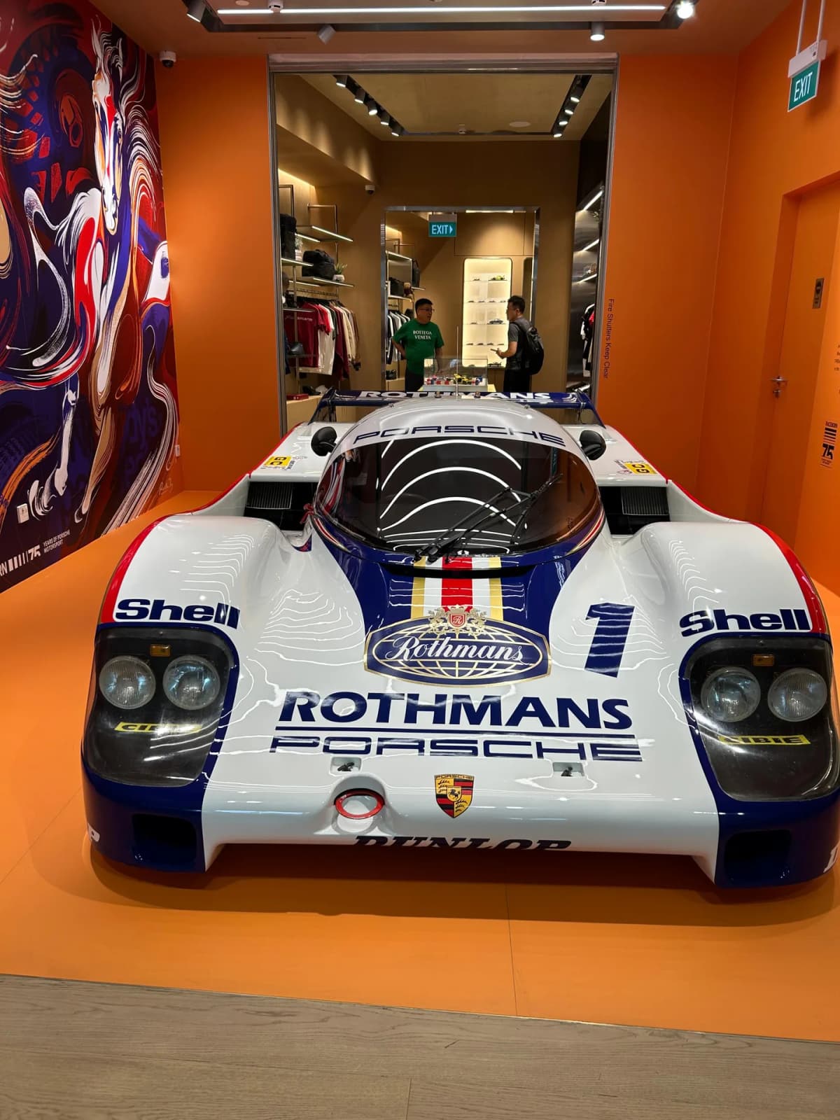 A Rothmans-liveried Porsche 956 race car displayed inside the Porsche Design store at Jewel Changi Airport